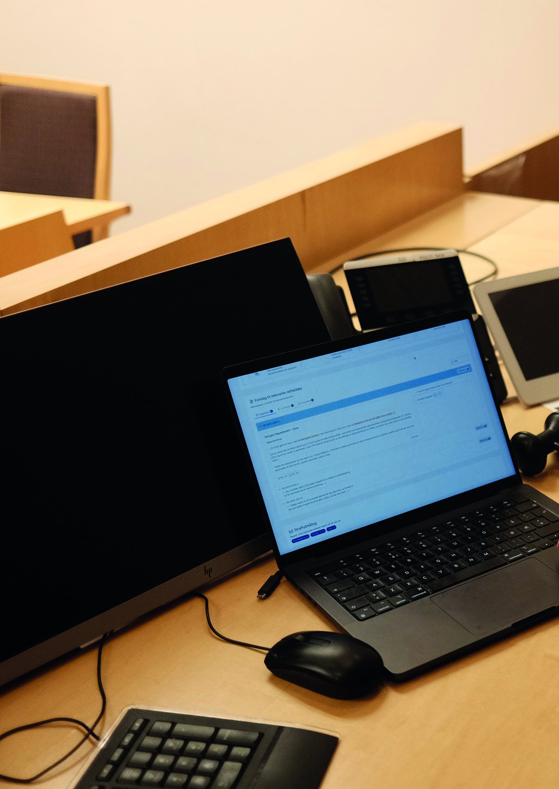 Bærbar PC med Saksblikk åpent på en pult i en rettssal.